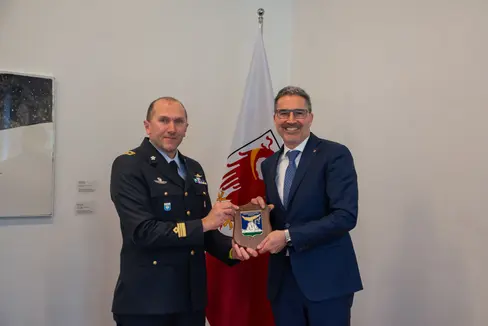 Da sinistra, il tenente colonnello Nicola Bolzan e il presidente della Provincia autonoma di Bolzano Arno Kompatscher posano con il distintivo del Distaccamento aeroportuale di Dobbiaco. (Foto: ASP/Greta Stuefer)