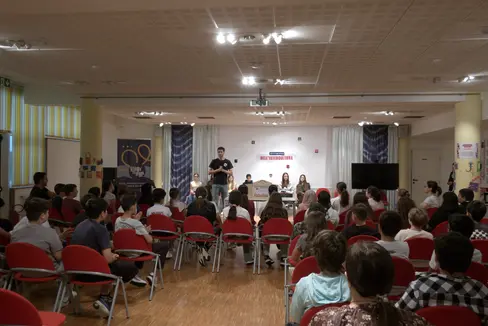 Ragazze e ragazzi durante l'evento tenutosi al Centro Giovanile Terraferma a Don Bosco: qui il saluto sul palco di Gabriele Guatteri, responsabile pedagogico. (Foto: TV33)