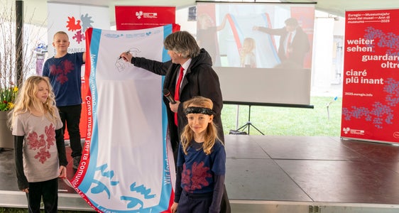 Statt eines Spruchs zeichnet Peter Schwienbacher, Direktor der Hofburg Brixen, ein Strichmännchen auf die Fahne, das mit einer Laterne das (historische, gegenwärtige und zukünftige) Umfeld ausleuchtet. (Foto: LPA/Daniel von Johnston)