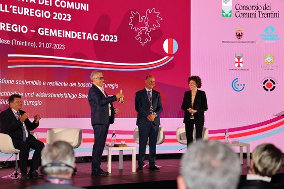 Die Übergabe der Glocke und damit des Vorsitzes des Euregio-Rates der Gemeinden von Paride Gianmoena (Trentino) an Südtirols Gemeindenpräsident Andreas Schatzer. (Foto: Presseamt Trentino/Juliet Astafan)