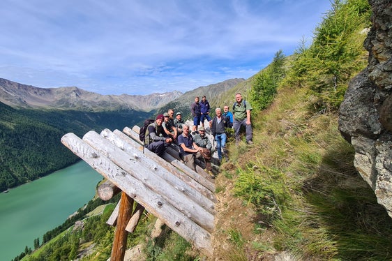Foto di gruppo sulle strutture in legno di protezione dalle valanghe: gli operatori dell'Ufficio sistemazione bacini montani Ovest con i colleghi dell'Ispettorato forestale di Merano durante una visita al sistema di protezione delle valanghe Hochegg a Vernago in Val Senales (Foto: ASP/Ispettorato forestale di Merano)