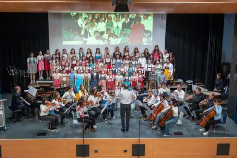 La Scora de musiga dla Val Badia complësc 50 agn: Le cor dla scora y l'orchestra sot la bachëta de Bruno Rives (Foto: OSP/Freddy Planinschek)