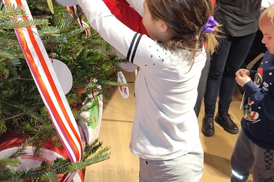 Mit der Hilfe von Valentina Stecchi haben die Kinder am Ende des Workshops auch den Christbaum mit ihren Werken geschmückt. (Foto: Euregio/Armin Gluderer)