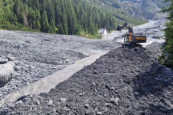 Die Wildbachverbauung hat nach dem Abgang einer Mure im Pleisserbach in Trafoi mit den Aufräumarbeiten begonnen; im Hintergrund links die Wallfahrtskirche zu den Heiligen drei Brunnen. (Foto: LPA/Amt für Wildbach- und Lawinenverbauung West in der Agentur für Bevölkerungsschutz)