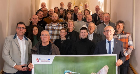 Gruppenfoto mit Euregio-Präsident, Tirols Landeshauptmann Anton Mattle (vorne rechts), Euregio-Generalsekretär Matthias Fink (links) und sowie den Fotografinnen und Fotografen des Euregio-Kalenders 2027 (Foto: Land Tirol/Sedlak)