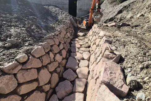 Zwischen März und September war die Wildbachverbauung im Schiedmanngraben südlich von Kollmann am Werk: Bergseits vom Schiedmannhof haben die Arbeiter eine 7 Meter hohe und 35 Meter breite Rückhaltesperre aus Stahlbeton errichtet und anschließend eine 30 Meter lange Künette (im Bild). (Foto: LPA/Landesamt für Wildbach- und Lawinenverbauung Nord in der Agentur für Bevölkerungsschutz/Johannes Holzner)