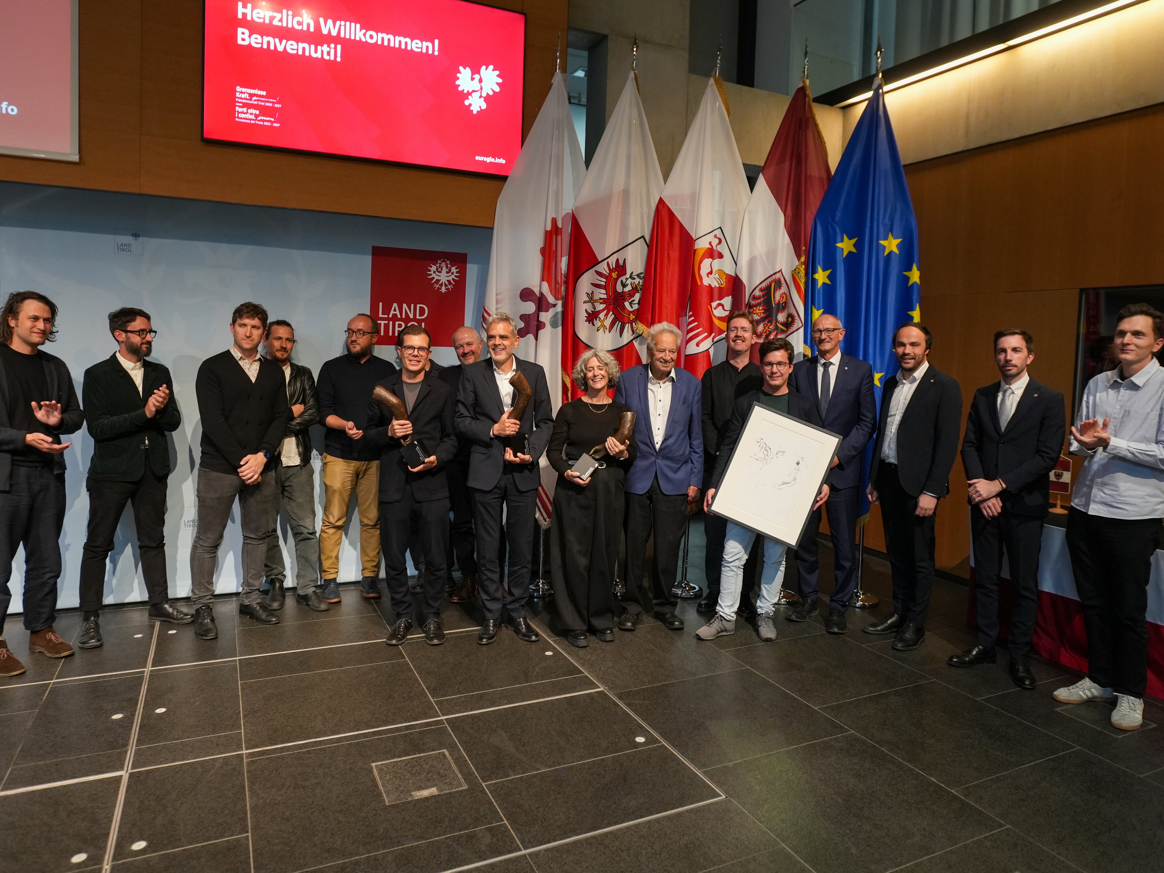 Euregio-Präsident, Landeshauptmann Anton Mattle, die Landesräte Philipp Achammer (Südtirol) und Simone Marchiori (Trentino), Landeshauptmann außer Dienst Wendelin Weingartner sowie Lois Anvidalfarei gratulieren den Preisträgern und Preisträgerinnen der Euregio-Baukulturpreise, Studio Lois, Lukas Mayr und Campomarzio sowie den Preisträgern des Publikumspreises „he und du“. (Foto: Land Tirol/Danijel Jovanovic)