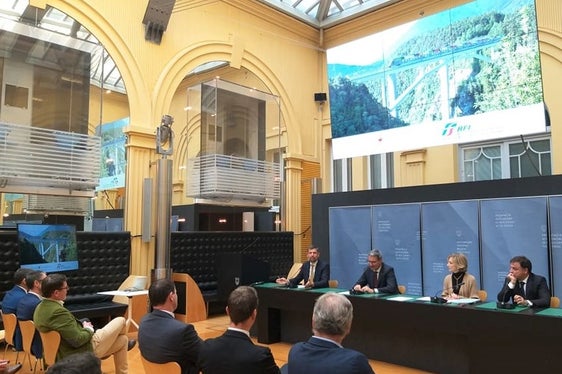 Die Riggertalschleife bringe 17 Minuten Zeitersparnis, direkte Verbindungen sowie neue Bahnhöfe in Natz-Schabs und Vahrn, hieß es bei der Unterzeichnung der Verordnung fürs endgültige Projekt mit (am Podium v.l.) LR Alfreider, LH Kompatscher, RFI-Kommissarin Firmi und RFI-Vertreter Romeo. (Foto: LPA/Angelika Schrott)