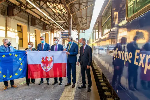 Der Connecting Europe Express zeigt die verbindende Kraft der Schiene. Am Bahnhof Bozen kam es heute vor Abfahrt des Zuges zum Fahnentausch: (v.l.) Pat Cox, RFI-Geschäftsführerin Vera Fiorani, LH Kompatscher, LR Alfreider sowie die EU-Vertreter Herald Ruijters und Kristian Schmidt. (Foto: LPA/Peter Daldos)