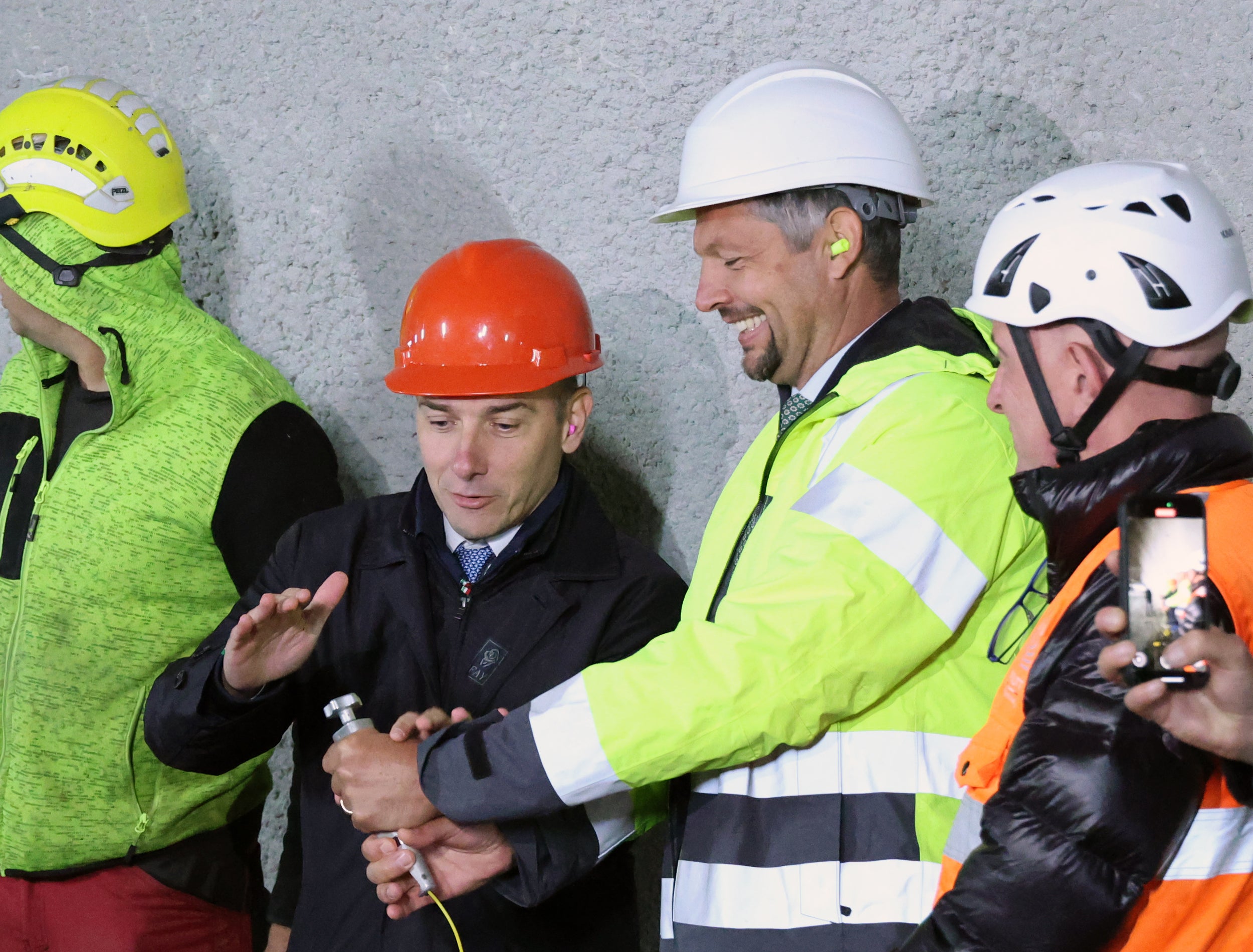 Mobilitätslandesrat Daniel Alfreider dankt dem Staatssekretär im Präsidium des Ministerrats, Alessandro Morelli, der die CIPESS-Verfahren für die italienische Regierung begleitet. Das Bild zeigt Alfreider (Mitte rechts) gemeinsam mit Morelli (Mitte links) beim Durchschlag der letzten Trennwand im Tunnel von Percha im Oktober 2025. (Foto: LPA/Ingo Dejaco)