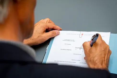 Hermann Troger firma la bozza di accordo in qualità di presidente dell'Agenzia provinciale per le relazioni sindacali (Foto: ASP/Fabio Brucculeri)