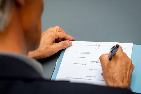Hermann Troger firma la bozza di accordo in qualità di presidente dell'Agenzia provinciale per le relazioni sindacali (Foto: ASP/Fabio Brucculeri)