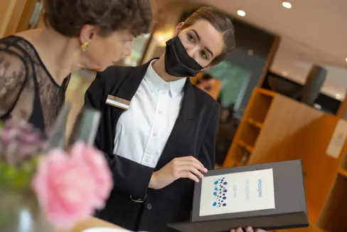 Direktorin Beatrix Kerschbaumer (l.) mit einer von sieben Kandidatinnen und Kandidaten, die ihr Können im Bereich Service vor den Augen der Prüfungskommission und den geladenen Gästen zeigte. (Foto: LPA/Landesberufsschule Savoy)