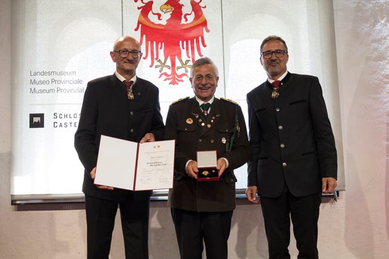 I presidenti Anton Mattle (a sinistra) e Arno Kompatscher (a destra) hanno consegnato ad August Tappeiner di Silandro la croce al merito per i suoi servizi resi alla Federazione altoatesina tiro a segno. (Foto: Land Tirol/Sedlak)