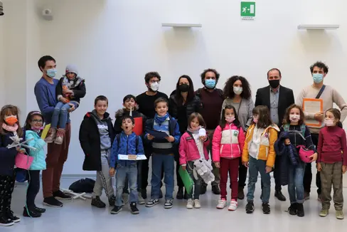 L'assessore Giuliano Vettorato insieme agli organizzatori e ai bambini durante la premiazione del progetto Imagination Island. (Foto ASP)