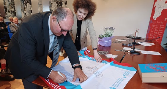 „Jedes Objekt erzählt. Jedes Schweigen sagt uns etwas“, schreibt MITAG-Präsident Oswald Mederle, assistiert von Elisa Bertò, Mitglied des Euregio-Generalsekretariats, auf die Euregio-Museumsjahr-Wanderfahne. (Foto: MITAG)