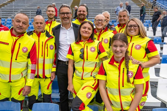 Il presidente della Provincia Arno Kompatscher posa con una delegazione della Croce Bianca, parte attiva assai preziosa durante la recente edizione dei Giochi Olimpici Invernali ad Anterselva. (Foto: USP/Othmar Seehauser)