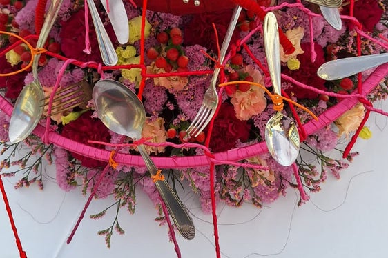 Fiori legati intervallati da forchette, coltelli, cucchiai e altri utensili da cucina. (Foto: USP/Scuola professionale per l'economia domestica e agroalimentare Aslago)