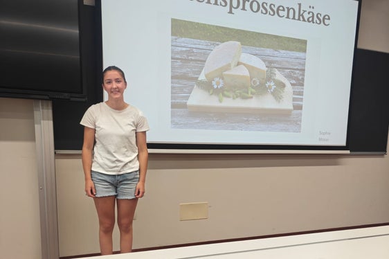Una studentessa del 4° anno del corso di Tecnologie Alimentari della Scuola professionale Laimburg durante la presentazione del formaggio ai germogli di abete rosso da lei ideato. (Foto: USP/Scuola professionale Laimburg)
