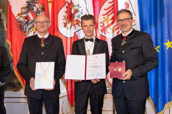 Il presidente del Land Tirolo Anton Mattle (a sinistra) e il presidente della Provincia autonoma di Bolzano Arno Kompatscher (a destra) consegnano l'onorificenza al musicista altoatesino Herbert Pixner (Foto: Land Tirol/Die Fotografen)