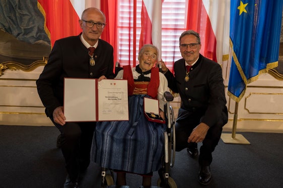 Insignita della croce al merito del Land Tirol dai presidenti provinciali Anton Mattle (a sinistra) e Arno Kompatscher (a destra): Hermine Aloisia Mayr Orian di Scena. (Foto: Land Tirol/Sedlak)