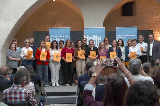 Bei der Grundausbildung geht es um die Vermittlung von Literatur, ebenso um Leseförderung, Öffentlichkeits- und Veranstaltungsarbeit und Zusammenarbeit mit Partnern. Im Bild ein Teil der Absolventinnen und Absolventen 2026 mit Amtsdirektorin Gamper (rechts) und Landesrat Achammer (links). (Foto: Amt für Bibliotheken und Lesen)