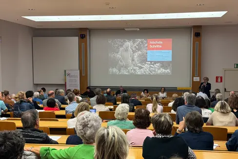 Esempi pratici da Bressanone e Bolzano (nella foto sul palco Carlo Alberto Librera, direttore della Ripartizione Servizi alla comunità locale del Comune di Bolzano) hanno mostrato quali possibilità esistono già per creare spazi di vita per anziani attivi. (Foto: USP/Katharina Fleischmann)