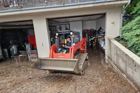 Die Berufsfeuerwehr Bozen unterstützt die Freiwillige Feuerwehr Trens mit einem Kleinbagger bei der Räumung einer Tiefgarage in Trens. (Foto: LPA/Berufsfeuerwehr Bozen)