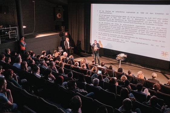 Konrad Pamer, Direktor des Amtes für Jugendarbeit, und Klaus Nothdurfter, ehemaliger Direktor des Amtes für Jugendarbeit im gut gefüllten Kinosaal des Filmclubs Bozen anlässlich der Veranstaltung 40 Jahre Landesgesetz zur Förderung der Jugendarbeit. (Foto: Philip Unterholzner/netz Offene Jugendarbeit)