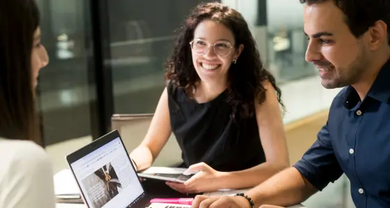 Due donne e un uomo conversano seduti a un tavolo. Due donne e un uomo conversano seduti a un tavolo.