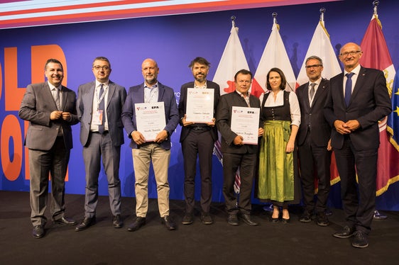 Il podio del Premio Euregio per l'innovazione: con i diplomi da sinistra Nicola Baraldi (3° classificato), Tommaso Morbiato (1° classificato), Andreas Bangheri (2° classificato) con (da sinistra) Marcus Hofer (presidente della giuria e direttore generale dell'Agenzia di sviluppo economico territoriale del Tirolo), il presidente Fugatti, Barbara Thaler (vicepresidente della Camera di Commercio del Tirolo e parlamentare europea), il presidente Kompatscher e il presidente Mattle (Foto: Land Tirol/Sedlak)