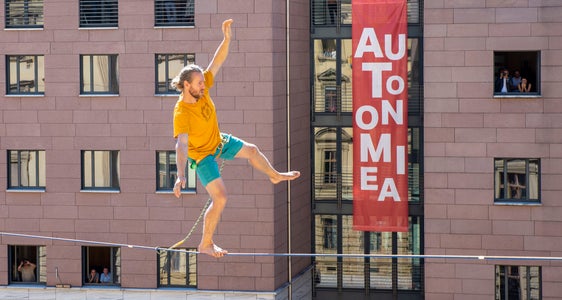 Autonomie als Balanceakt: Slackline-Weltrekordhalter Mich Kemeter aus der Steiermark hat am heutigen Tag der Autonomie den Silvius-Magnago-Platz auf einer 80 Meter langen Highline vom Landtagsgebäude zum Palais Widmann überquert. (Foto: LPA/Fabio Brucculeri)