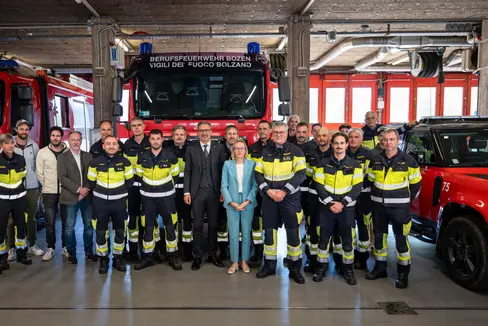 Insieme per un Corpo permanente dei vigili del fuoco forte: i rappresentanti del Corpo permanente dei vigili del fuoco con l’assessora provinciale al Personale Magdalena Amhof (in primo piano al centro), il presidente della Provincia Arno Kompatscher (a sinistra di Amhof) e il comandante del Corpo permanente dei vigili del fuoco di Bolzano, Florian Alber (a destra di Amhof), in occasione della presentazione del nuovo contratto nel deposito veicoli del Corpo permanente dei vigili del fuoco di Bolzano. (Foto: USP/Fabio Brucculeri)