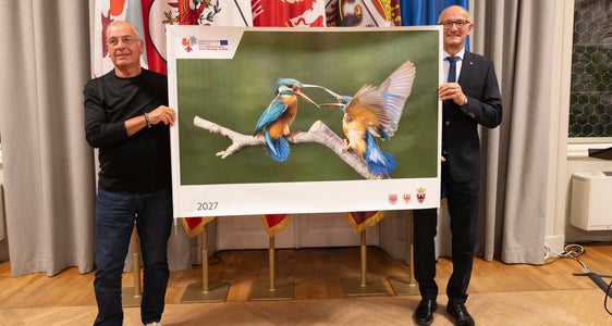 Das enthüllte Titelfoto mit (von links) Fotograf Fernando Tait und Euregio-Präsident, Tirols Landeshauptmann Anton Mattle. (Foto: Land Tirol/Sedlak)
