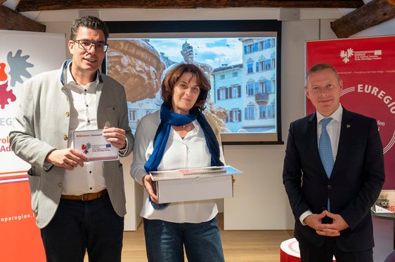 Lorenza Panizza, trentina di Roverè della Luna, posa davanti alla sua splendida foto della fontana del Nettuno di piazza Duomo, a Trento, tra Matthias Fink (a sinistra) e Christoph von Ach (a destra). (Foto: ASP/Fabio Brucculeri)