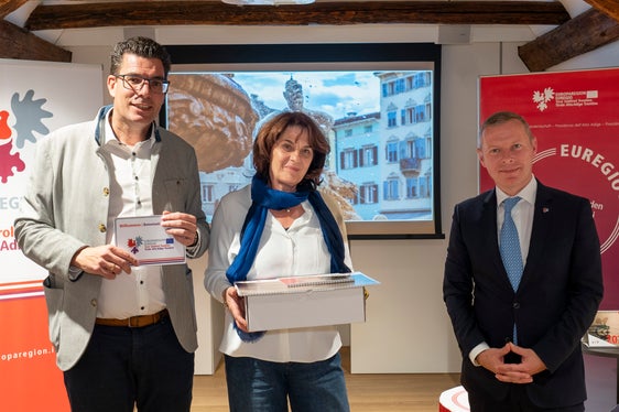 Lorenza Panizza, trentina di Roverè della Luna, posa davanti alla sua splendida foto della fontana del Nettuno di piazza Duomo, a Trento, tra Matthias Fink (a sinistra) e Christoph von Ach (a destra). (Foto: ASP/Fabio Brucculeri)