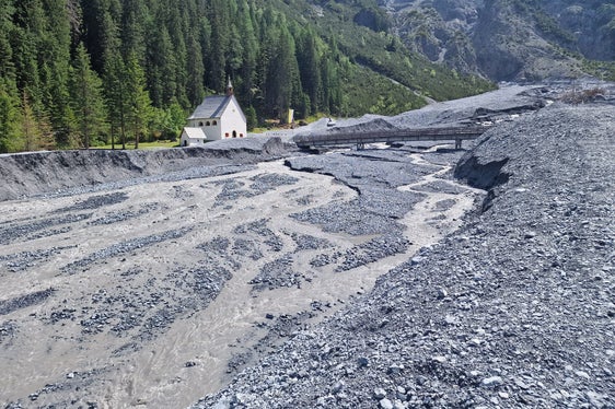 Die Wildbachverbauung hat nach dem Abgang einer Mure im Pleisserbach in Trafoi mit den Aufräumarbeiten begonnen; links im Bild die Wallfahrtskirche zu den Heiligen drei Brunnen. (Foto: LPA/Amt für Wildbach- und Lawinenverbauung West in der Agentur für Bevölkerungsschutz)