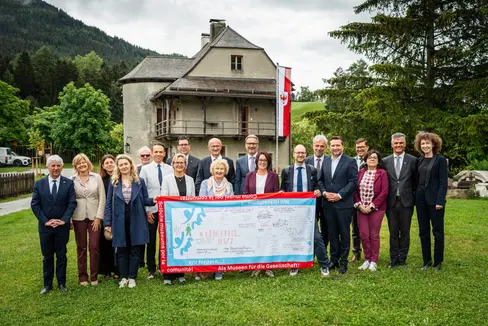 Symbolischer Abschluss des Euregio-Museumsjahrs 2025: Vertreterinnen und Vertreter der Museumsjahr-Steuerungsgruppe übergaben die Wanderfahne an die Euregio-Versammlung. (Foto: Land Tirol/Fitsch)