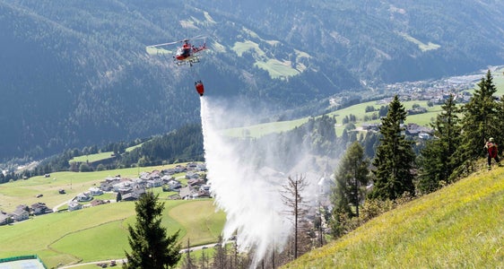 Collaborazione transfrontaliera durante l'esercitazione antincendio boschivo dell'Euregio: l'elicottero trentino scarica con precisione l'acqua sul terreno di esercitazione nel Tirolo Orientale. (Foto: Vigili del fuoco di Anras/Simon Kofler)