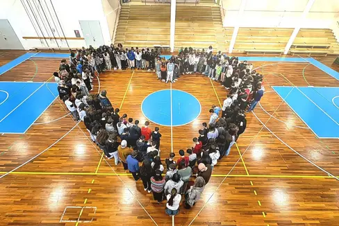 Insieme per una scuola forte e unita. Le ragazze e i ragazzi delle Fermi riuniti a cuore all'interno della palestra. (Foto: USP)