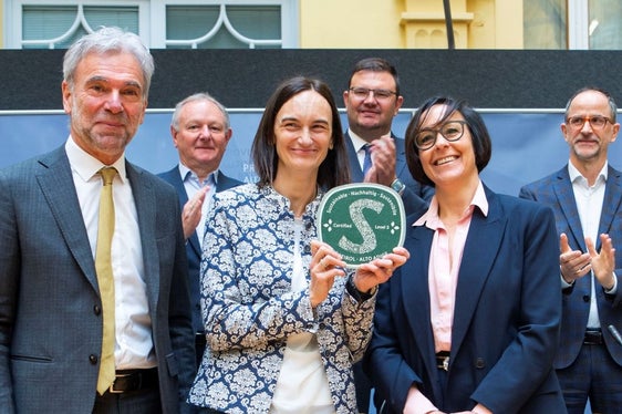 La destinazione Val d'Ega ha ottenuto il massimo livello di sostenibilità. La direttrice Verena Festi (con l'etichetta in mano) e Brigitte Zelger, componente del CdA di Val d'Ega Turismo Soc. Coop. (accanto a lei sulla destra) hanno ricevuto la certificazione dall'assessore provinciale Arnold Schuler (a sinistra) durante la conferenza stampa. Presenti anche il presidente di HGV Manfred Pinzger (in ultima fila, all'estrema sinistra), il presidente di IDM Hansi Pichler (in fondo, al centro) e il direttore di IDM Erwin Hinteregger (Foto: ASP/Fabio Brucculeri)