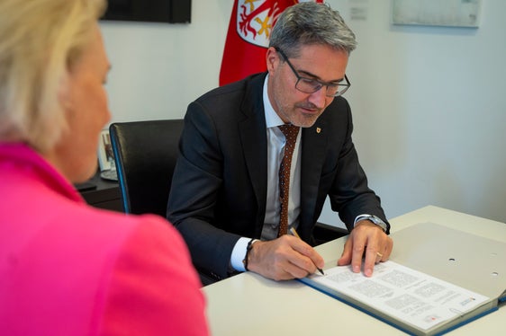 Il presidente Kompatscher appone la firma sull'accordo di tirocinio (Foto: ASP/Fabio Brucculeri)