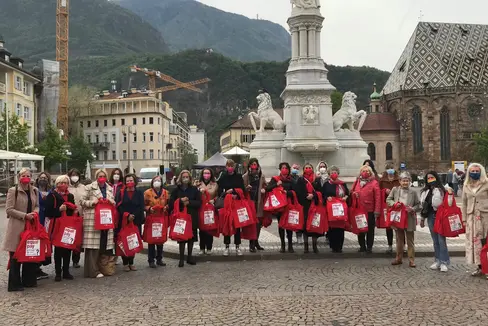 Con le note borse rosso sgargiante le organizzazioni femminili hanno chiesto l'eliminazione della disparità salariale di genere in Piazza Walther a Bolzano (Foto: ASP)
