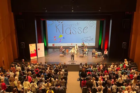 Bei den Singfesten werden die Schülerinnen und Schüler von einer besonderen Band begleitet; dazu gehören Andreas Benedikter (Klavier und Flöte), Manfred Gampenrieder (Perkussion) Barbara Prantl (Gitarre) und Rottensteiner Armin (Bass); in der Bildmitte: Hanno Deluggi, rechts im Bild: Sigrun Falkensteiner (Foto: LPA/Deutsche BIldungsdirektion)