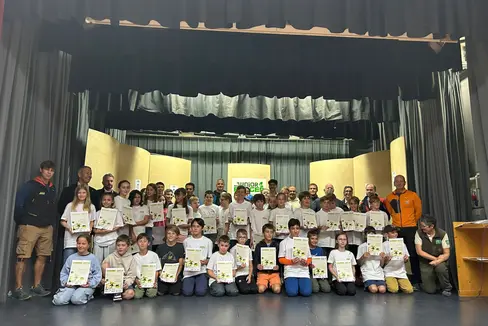 45 naturbegeisterte Kinder zwischen 10 und 11 Jahren haben am 2. August bei einer Feierstunde im Vereinssaal von Wengen ihre Naturpark Junior Ranger 2025-Diplome bekommen. Anwesend waren zahlreiche Ehrengäste wie Landesrat Peter Brunner (stehend, 2.v.l.) (Foto: LPA/Ralf Pechlaner)