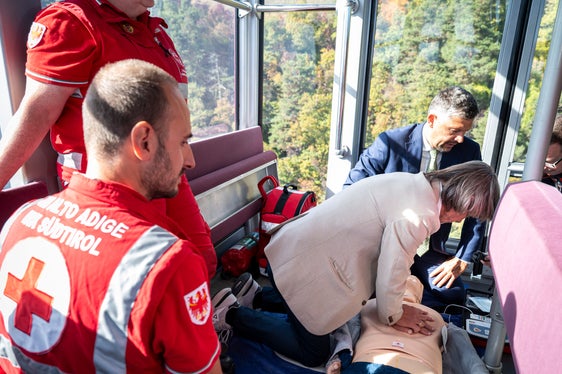 Bei der praktischen Vorführung zur Wiederbelebung in der Rittner Seilbahn machten auch Gesundheitslandesrat Hubert Messner und Mobilitätslandesrat Daniel Alfreider mit. Die Aktion soll darauf aufmerksam machen, dass im Notfall schnelles Eingreifen entscheidend sein kann. (Foto: LPA/Fabio Brucculeri)