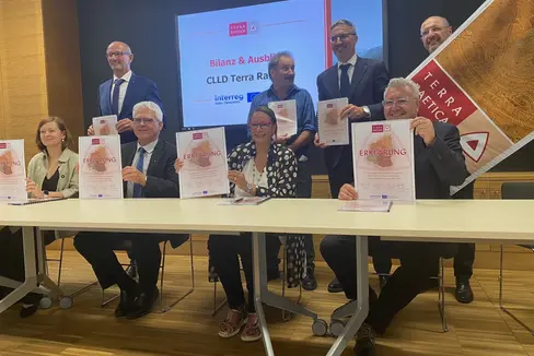 Plasmare il futuro insieme, a livello transfrontaliero e locale: questo è l'obiettivo della Strategia Interreg CLLD Terra Raetica. I rappresentanti delle due città di Imst e Nauders, della Bassa Engadina/Val Monastero e della Val Venosta hanno firmato l'accordo, assieme a loro in piedi da sinistra il presidente del Tirolo Anton Mattle, il presidente della Bassa Engadina/Val Monastero Victor Peer e il presidente Arno Kompatscher hanno fatto da padrini insieme al presidente del Consiglio Interreg Andreas Tappeiner (all'estrema destra, in piedi). (Foto: ASP/Martha Gärber).