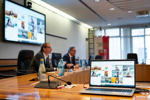 Klaus Unterweger (a sinistra), direttore dell'Agenzia per la Protezione civile, e il presidente della Provincia e assessore alla Protezione civile Arno Kompatscher hanno discusso con i membri del Centro operativo provinciale durante una videoconferenza: dopo i Giochi Olimpici Invernali 2026 ad Anterselva, l'organismo ha tracciato un bilancio positivo e ha elogiato la collaborazione professionale di tutte le organizzazioni e le forze di intervento coinvolte. (Foto: USP/Fabio Brucculeri)