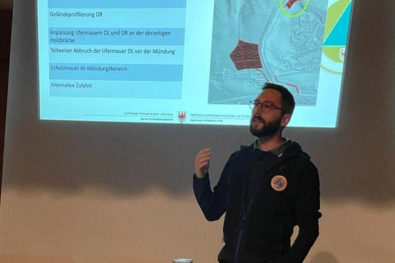 Techniker Jan Kobald stellte das Verbauungskonzeptes vor: Um ein Ausufern des Kogbachs im Mündungsbereich zu verhindern, müsste die Fläche eines dort stehenden Wohnhauses als Ausschotterungsfläche genutzt und mit einer rund 55 Meter langen Mauer umgrenzt werden. (Foto: LPA/Landesamt für Wildbach- und Lawinenverbauung Nord)