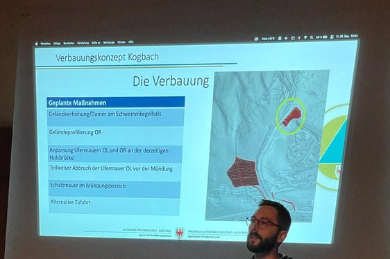 Techniker Jan Kobald stellte das Verbauungskonzeptes vor: Um ein Ausufern des Kogbachs im Mündungsbereich zu verhindern, müsste die Fläche eines dort stehenden Wohnhauses als Ausschotterungsfläche genutzt und mit einer rund 55 Meter langen Mauer umgrenzt werden. (Foto: LPA/Landesamt für Wildbach- und Lawinenverbauung Nord)